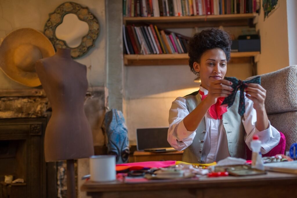 Designer sewing at desk in office